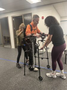 Robotic exoskeleton helping man with neurological impairment to walk