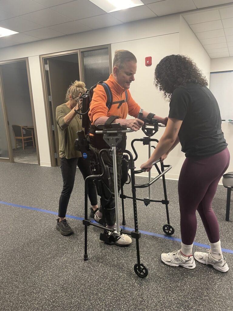 A Push to Walk patient working with exercise therapists and specialized equipment to regain mobility after a spinal cord injury